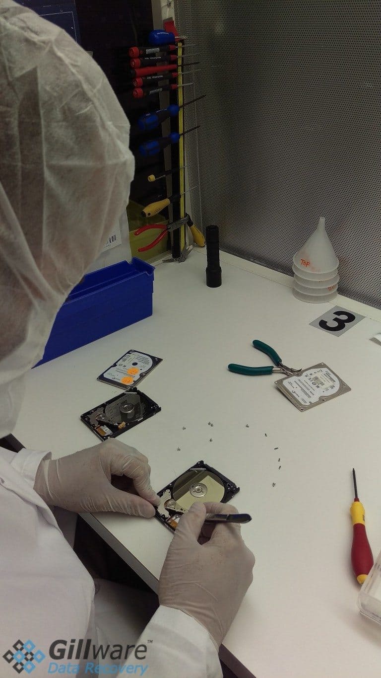 One of the data recovery engineers in our cleanroom inspects a hard drive