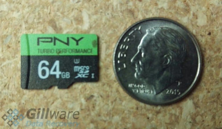 A size comparison of a 64 GB microSD card to a dime