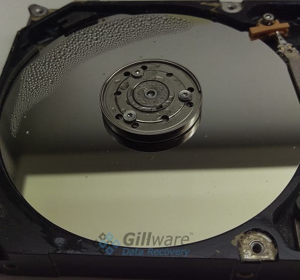 A water damaged hard drive. The platters will need to be carefully cleaned and dried in a data recovery lab.